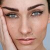 Moters veido artimas vaizdas su microblading antakiais ir natūraliu makiažu, tamsūs plaukai suri&scaron;ti