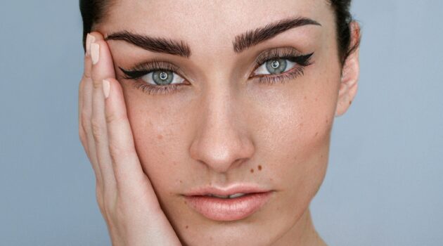 Moters veido artimas vaizdas su microblading antakiais ir natūraliu makiažu, tamsūs plaukai suri&scaron;ti