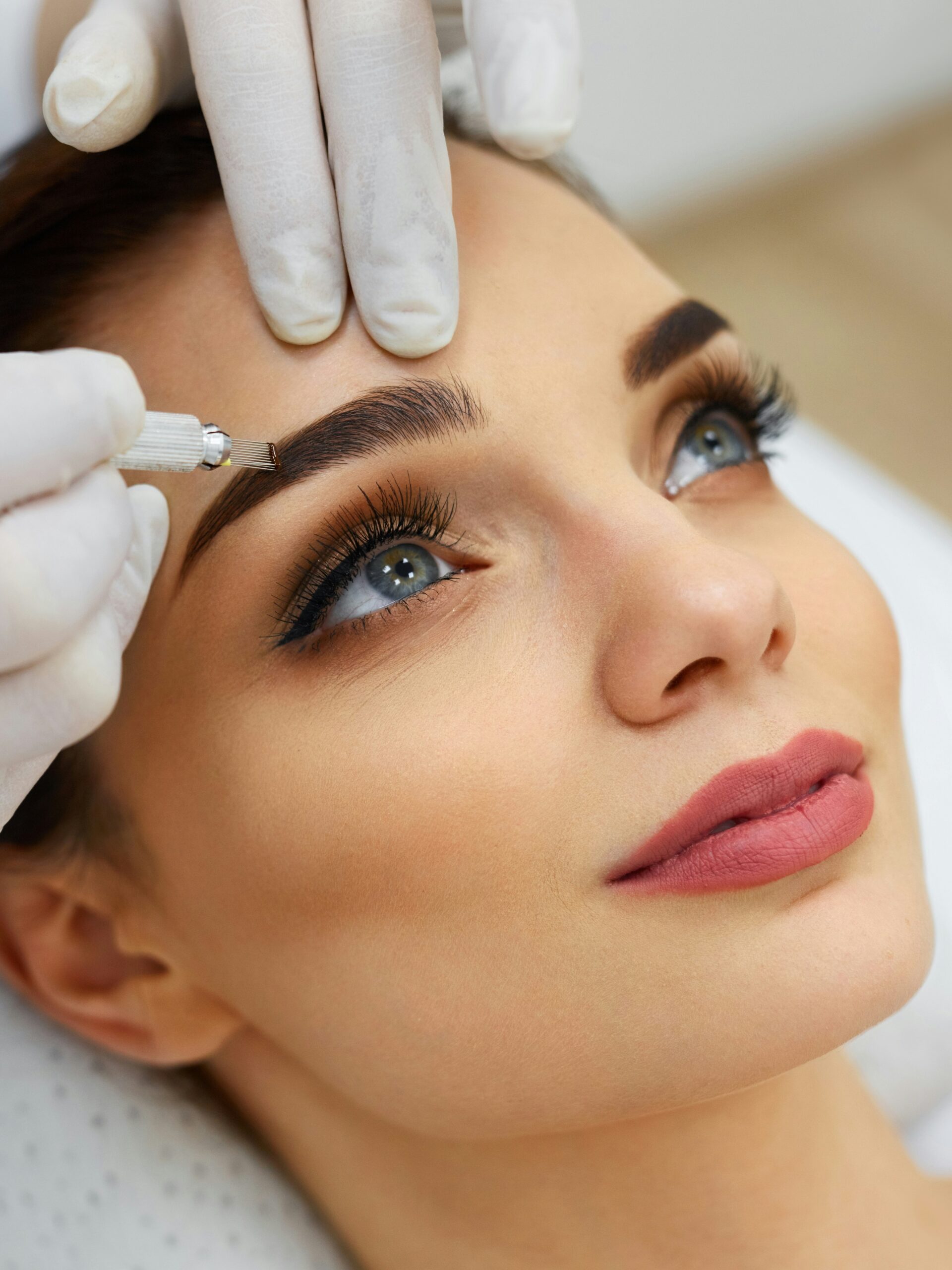 Moters veidas iš arti, salone atliekama microblading procedūra