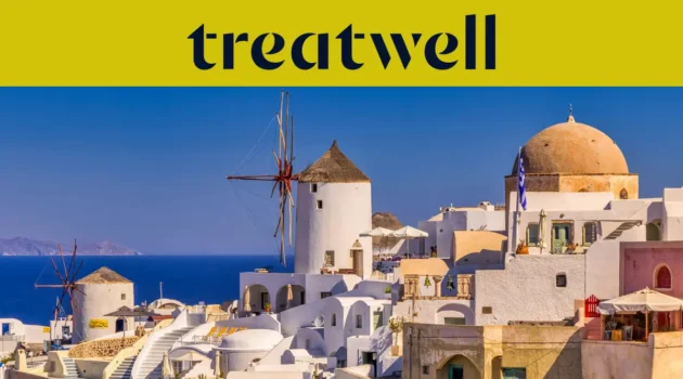 Baltai tinkuoti namai ir tradiciniai vėjo malūnai vir&scaron; tamsiai mėlynos Egėjo jūros Oia miestelyje, Santorinyje, po geltona juosta su Treatwell logotipu.