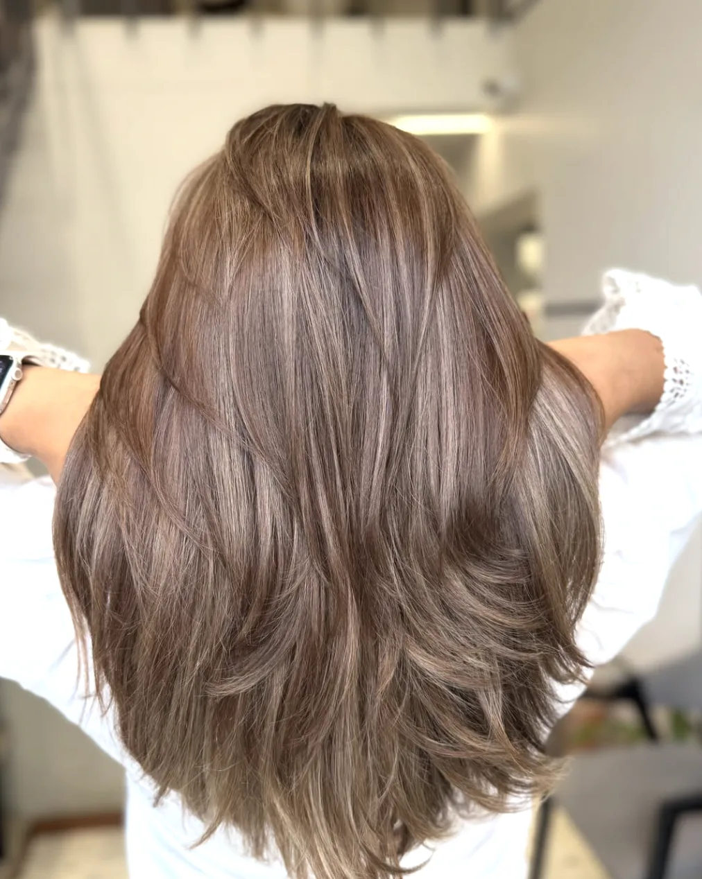 Ilgi, pakopomis kirpti plaukai daugiatoniu „taupe truffle“ rudu atspalviu